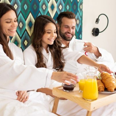 happy-young-beautiful-family-bathrobes-are-taking-morning-breakfast-luxury-hotel-room_283617-688